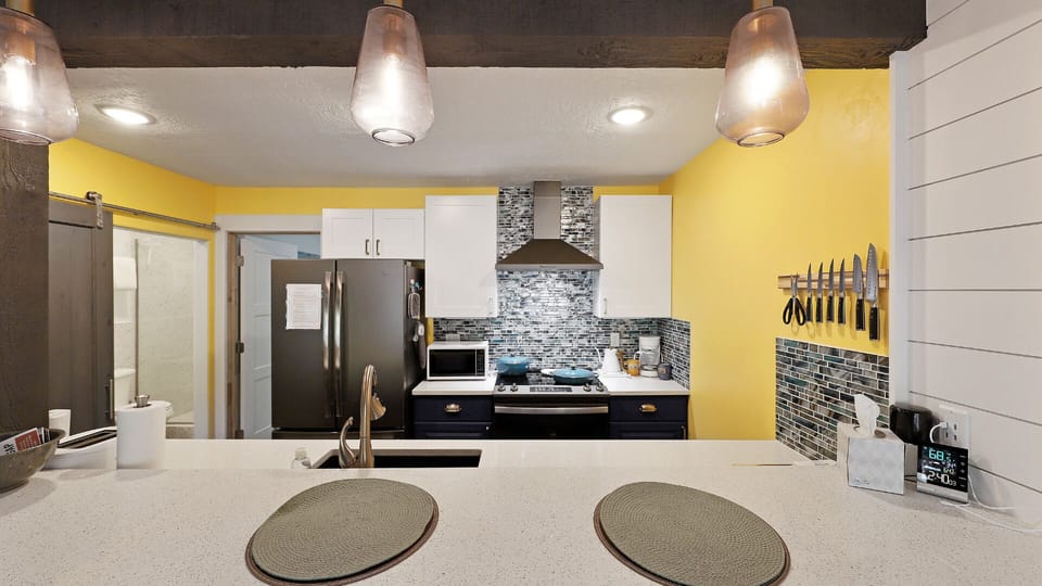 View of the galley kitchen with counter seating for two and upgraded appliances