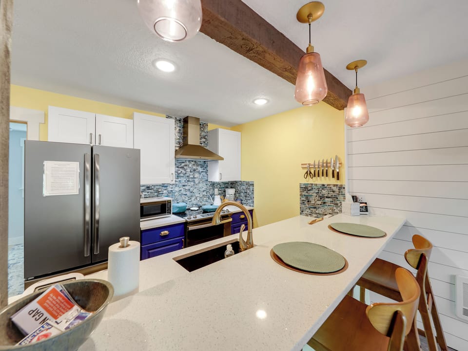 View of the galley kitchen with counter seating for two and upgraded appliances