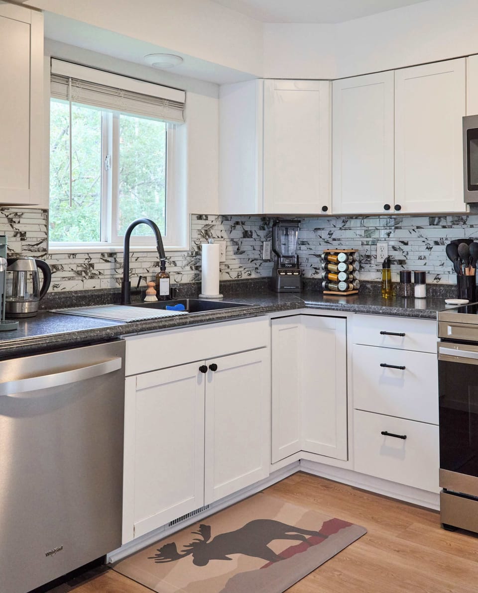 Bright and functional, the kitchen offers ample counter space, a dishwasher, and large sink with modern fixtures. A window brings in natural light, while well-stocked cabinets and essentials make it easy to prepare meals during your stay.