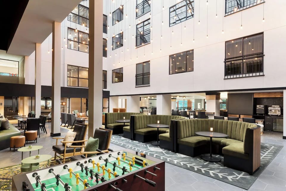 Unwind beneath glowing atrium lights in stylish lounge seating.