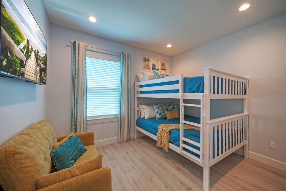 Bedroom 4 with two full-over-full bunk beds, TV, and private ensuite bathroom access.
