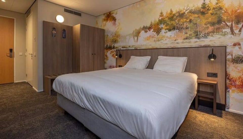 Unwind on crisp linens beneath a calming forest mural.