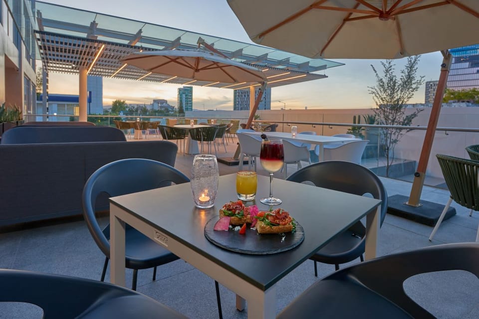 Sip sunset cocktails al fresco with skyline views and shade.