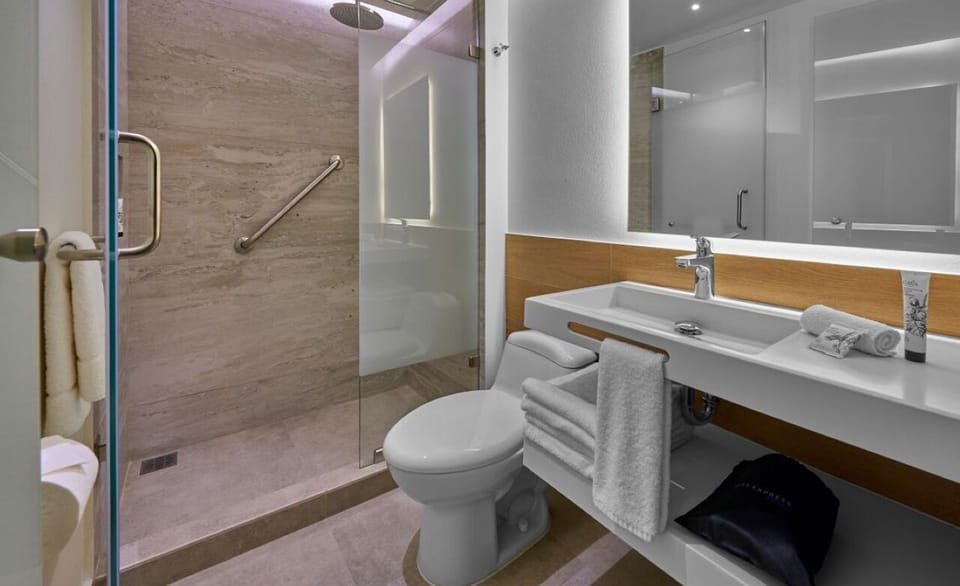 Refresh under a sleek glass shower in a spotless bath.
