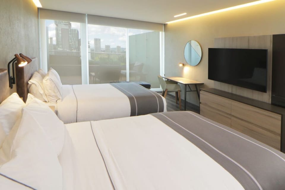 Wake up to city light through wide balcony windows.