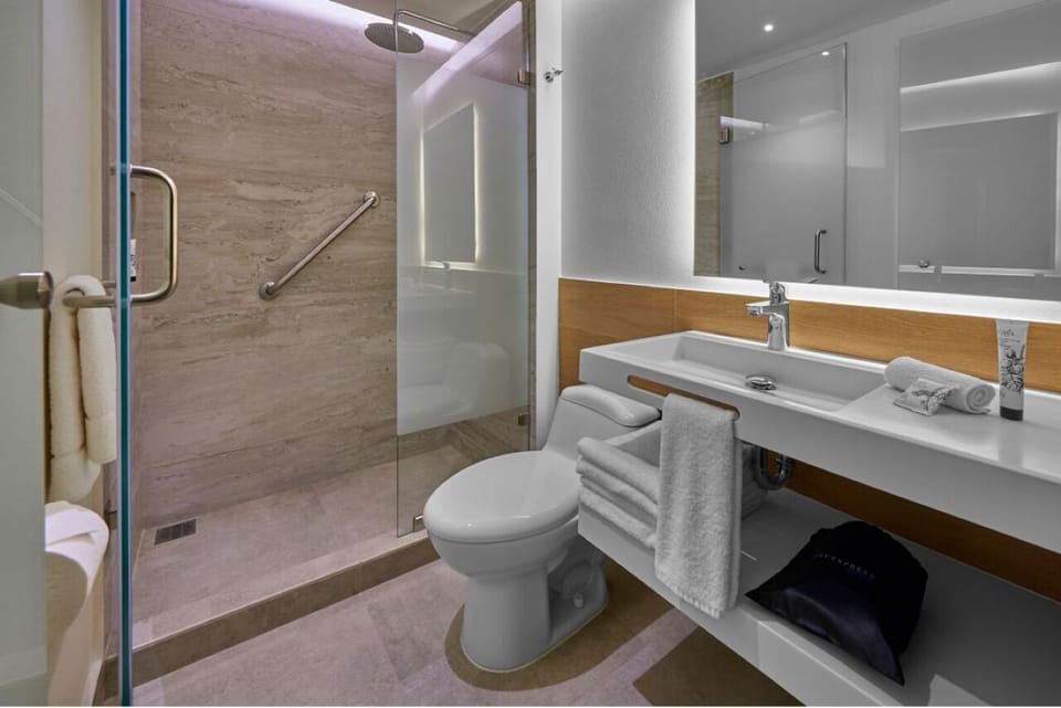Refresh under a sleek glass shower in a spotless bath.