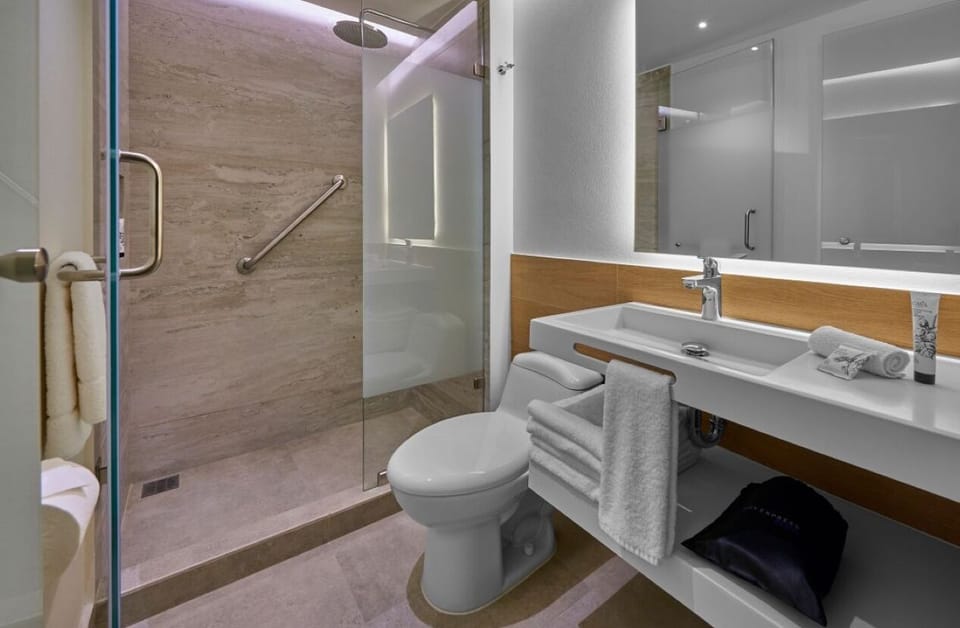 Refresh under a sleek glass shower in a spotless bath.
