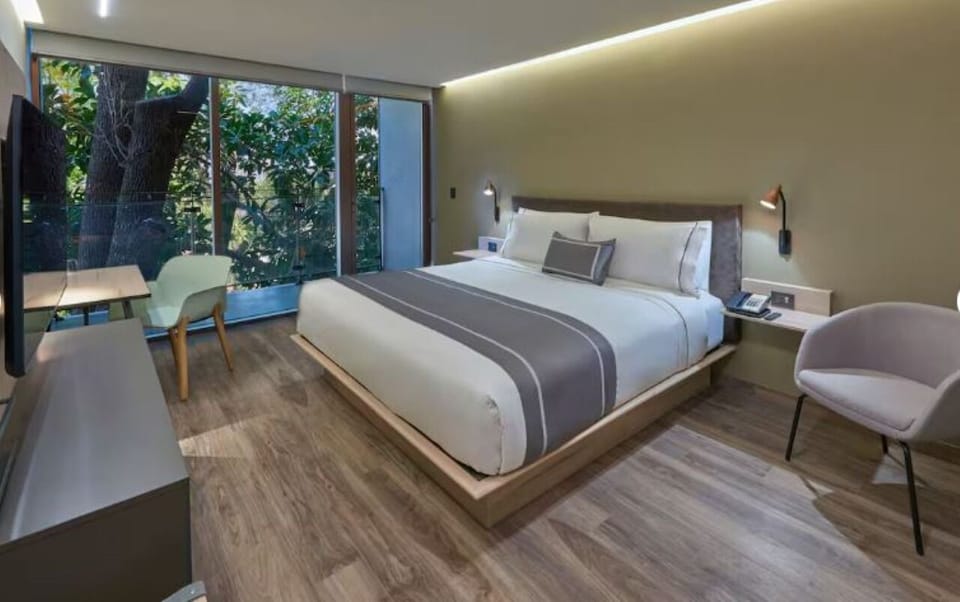 Unwind in a serene king bed with leafy views.