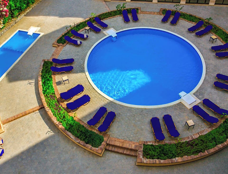 Dive into bright, inviting waters framed by loungers and gardens.