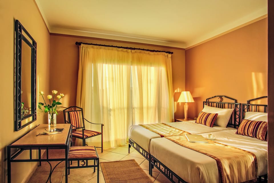 Sink into airy comfort with twin beds and golden sunlight.