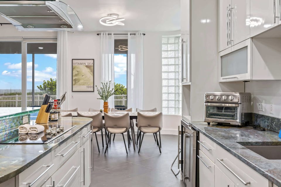 Modern kitchen and dining area with ocean views through large windows.