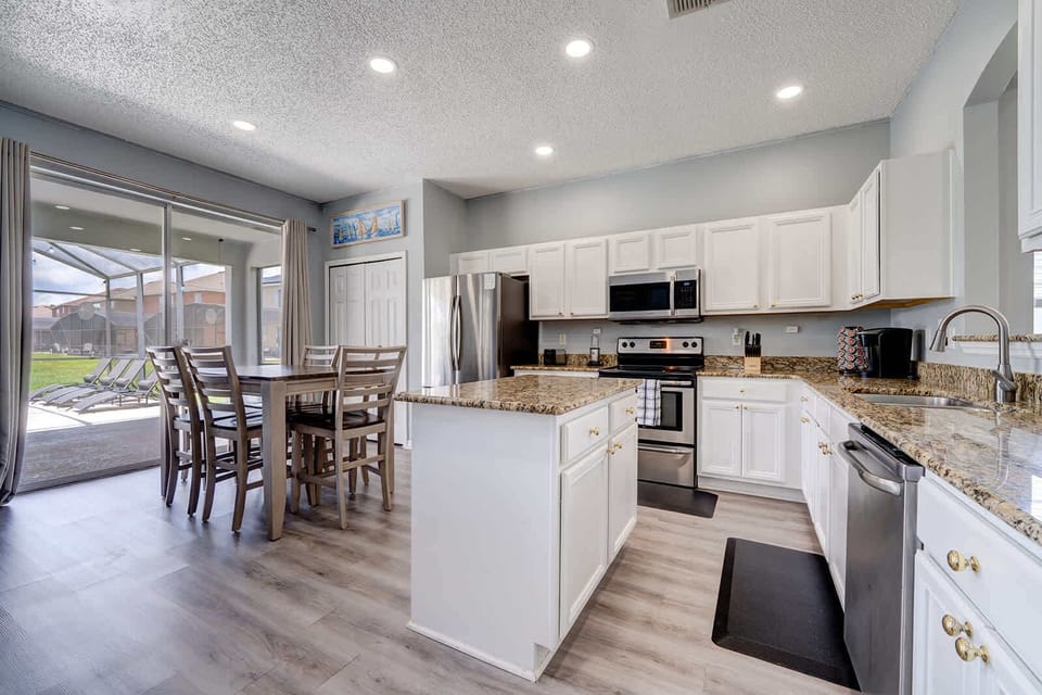 Kitchen flows into dining w/ white cabinetry & plenty of counter space.
