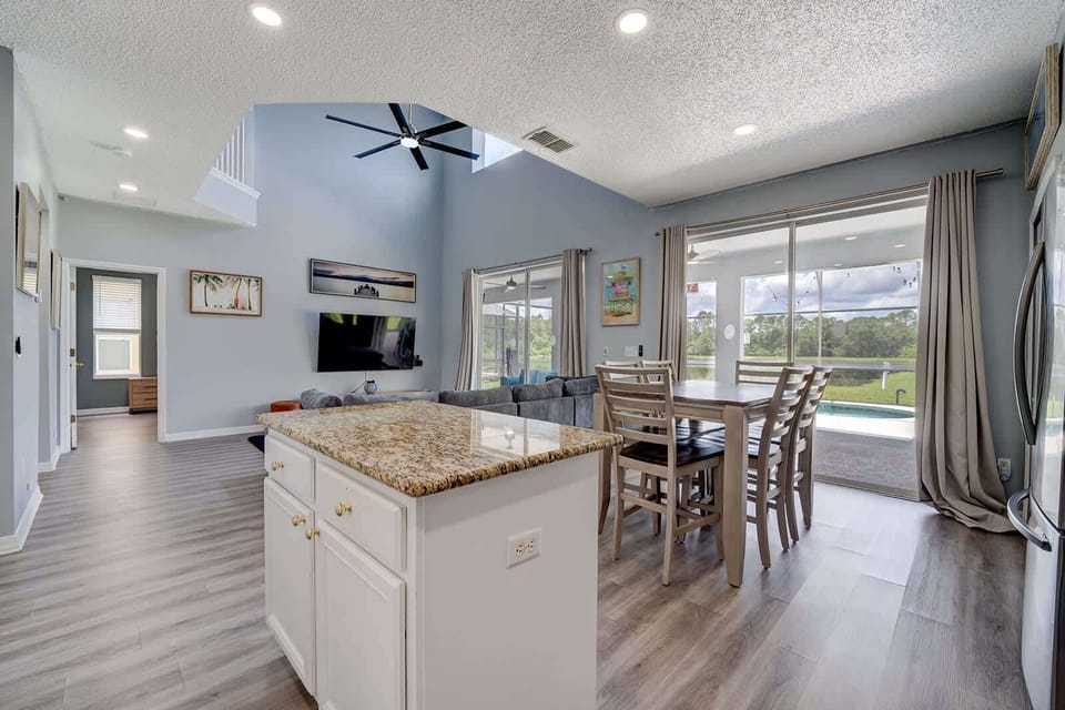 Bright kitchen w/ white island & open sightlines to the dining area.
