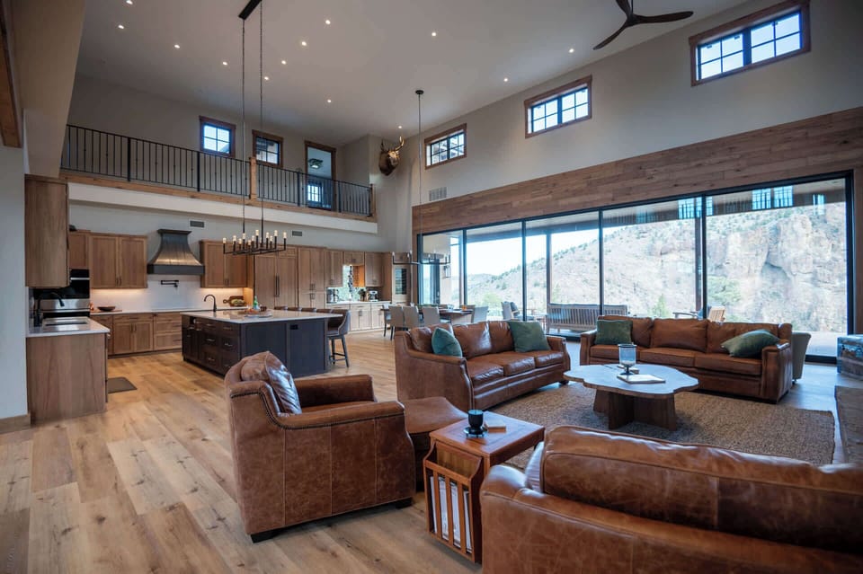 Expansive and light-filled, the great room features vaulted ceilings and retractable glass walls that open to sweeping canyon views—designed for effortless relaxation and entertaining.