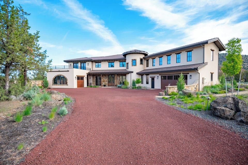 Striking front elevation showcasing the home’s natural stonework, warm wood accents, and timeless high-desert architecture.