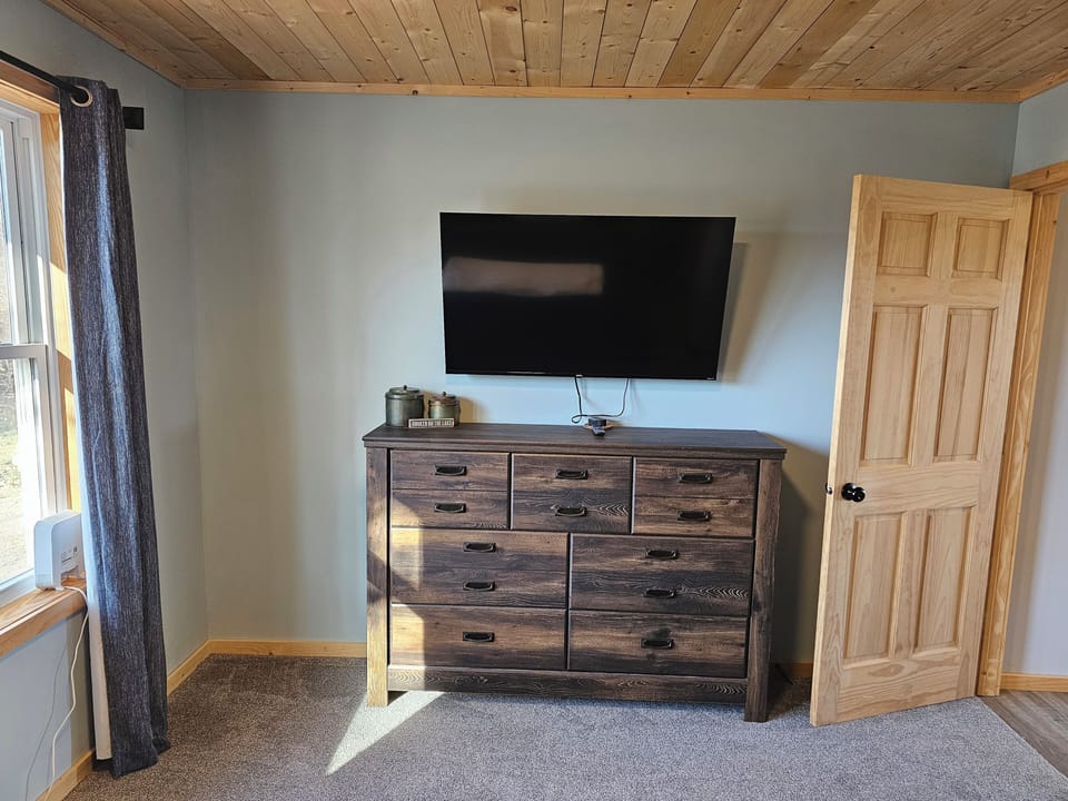 this is the second bedroom view from the bed. smart TV and large dresser.