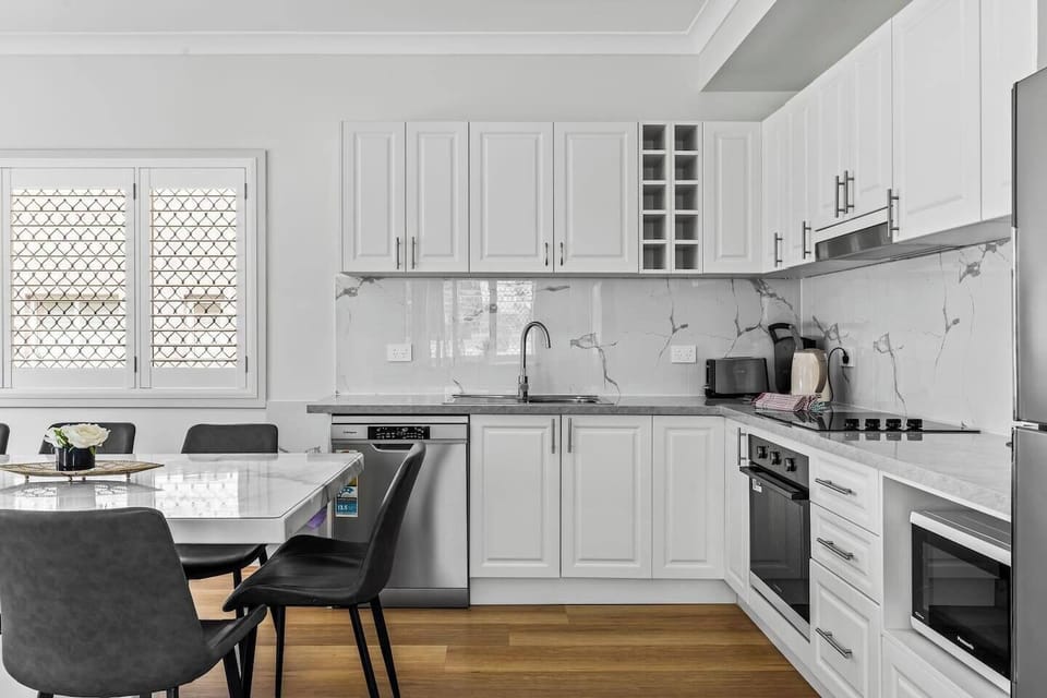 Prepare your favourite meals in the sleek, modern kitchen featuring marble splashbacks, a dishwasher and a Nespresso machine.