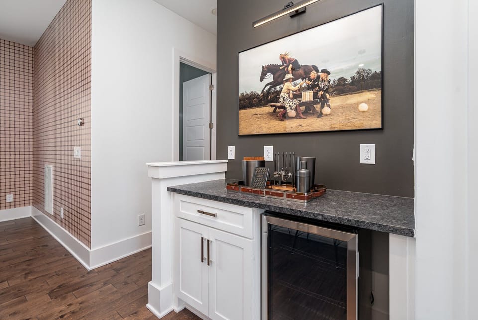 The fully equipped modern kitchen is stocked with all culinary essentials, stainless-steel appliances, breakfast bar seating, and mini bar area with wine cooler.  (2nd Floor)