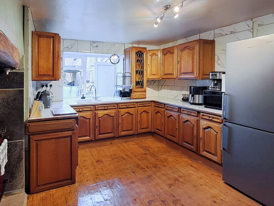 Kitchen with Rangemaster electric double oven in an inglenook fireplace. | Brockhill House, Beaminster