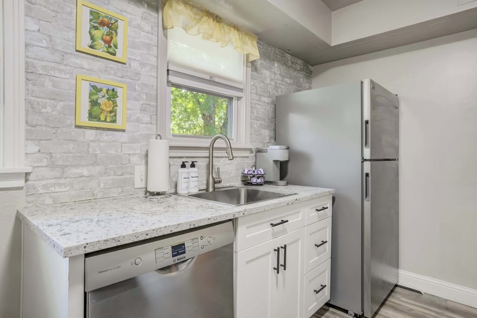 Spacious countertop prep area and stainless steel appliances meet thoughtful design in this bright, functional kitchen.

