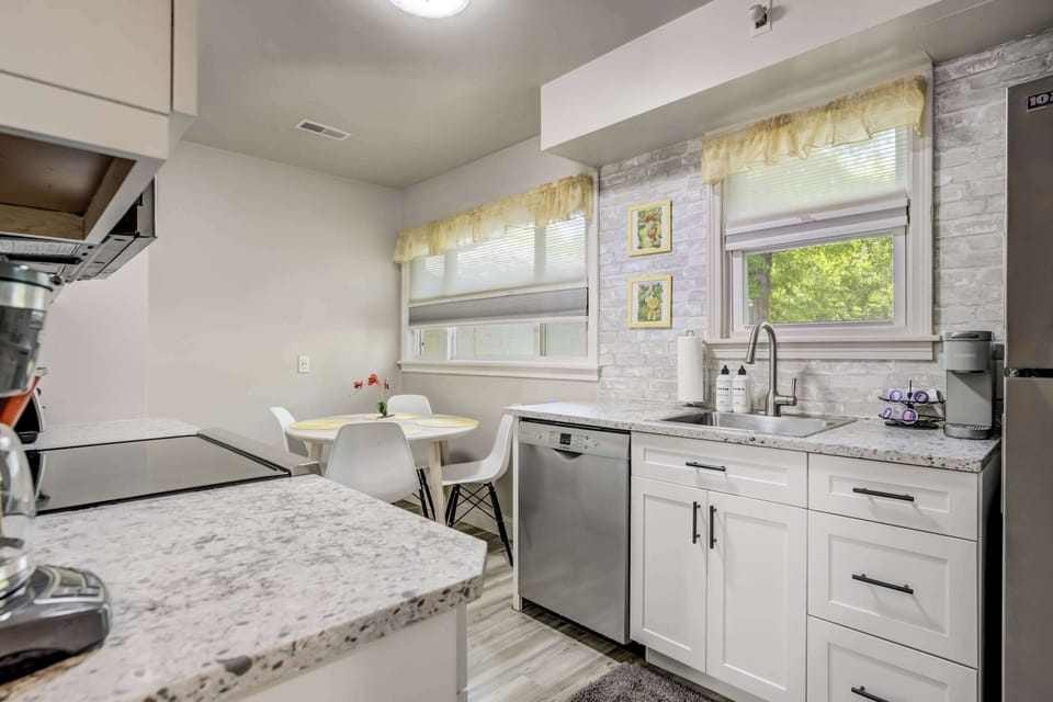 Spacious countertop prep area and stainless steel appliances meet thoughtful design in this bright, functional kitchen.


