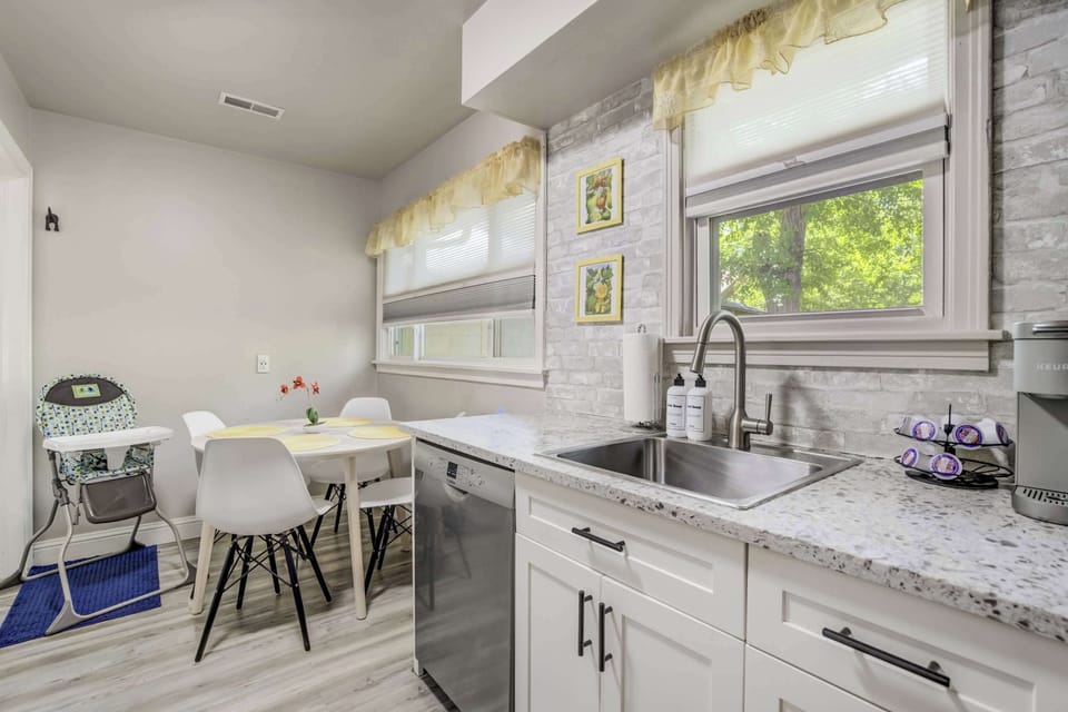 Well-equipped kitchen with coffee essentials, full-size appliances, and a bright dining space that includes a high chair for little ones.

