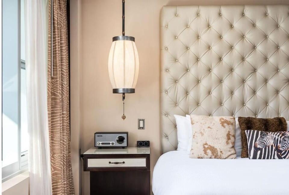 Recharge beside the tufted headboard with warm, ambient light.