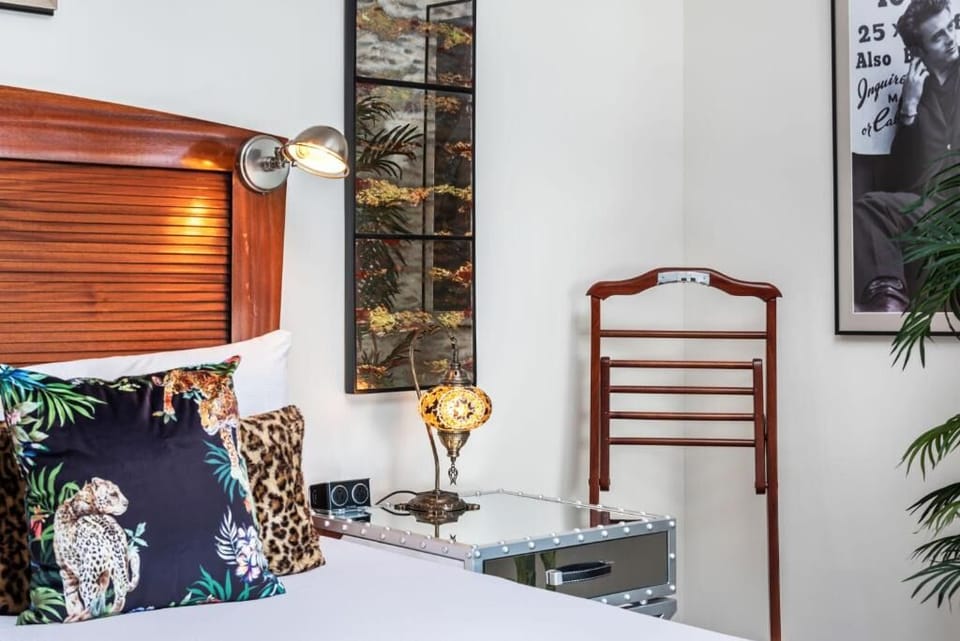 Unwind in crisp linens beside rich wood and artful decor.