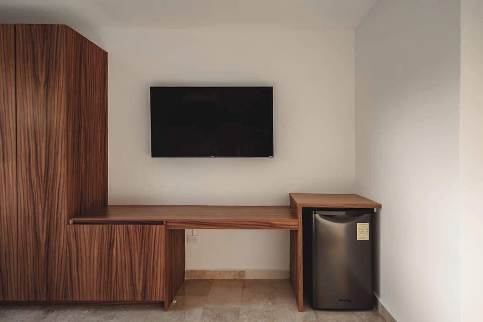 Guest Bedroom Features a Smart TV and Mini Fridge