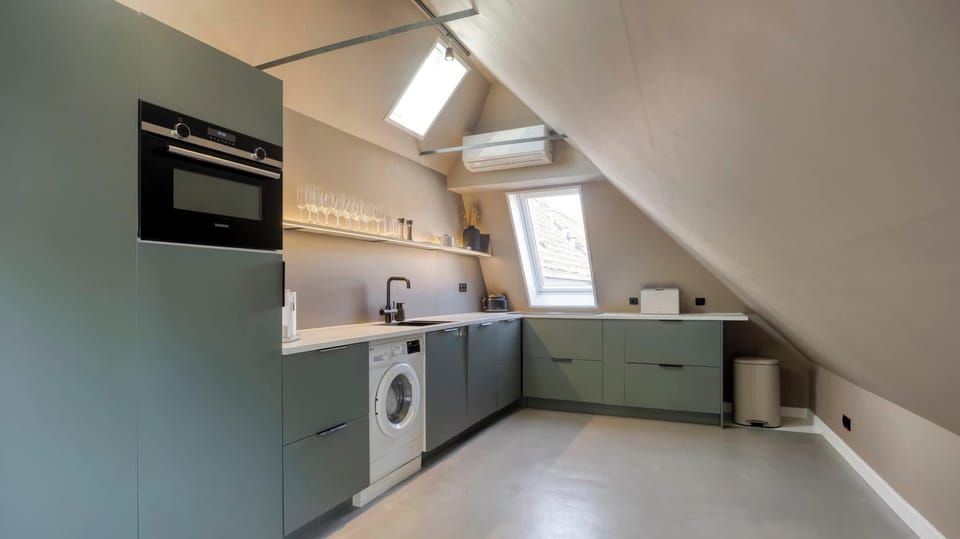 Smart, well-equipped kitchen under the eaves with oven, stove, dishwasher and washer-dryer combo.