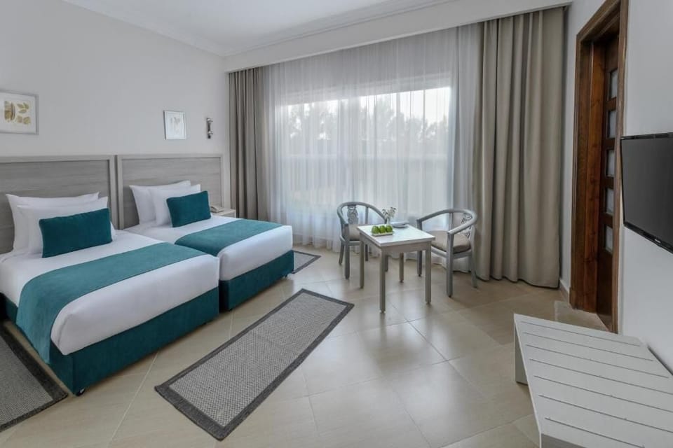 Unwind in crisp twin beds beside soft daylight curtains.