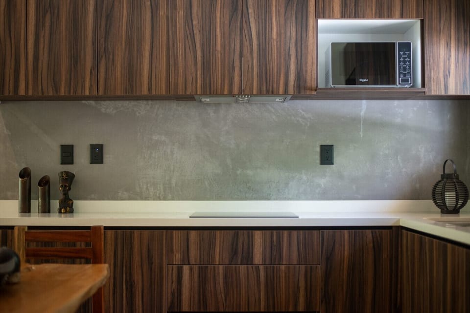 Stylish kitchenette with microwave and wood cabinets.
