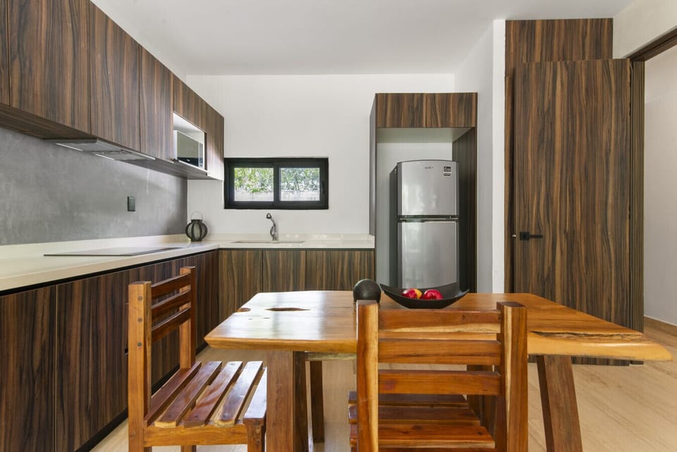 Modern kitchen with stainless steel and rustic dining table.