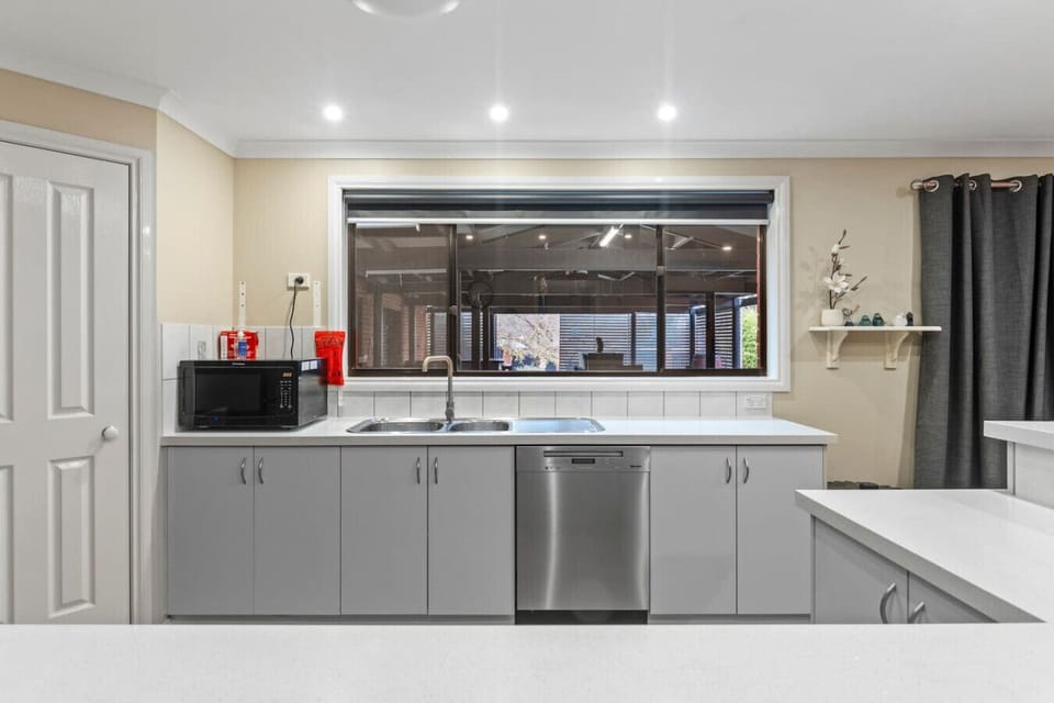 Spacious kitchen and dining area with large oven, perfect for family meals and entertaining.Enjoy the comfort of air conditioning, a TV for entertainment, and plenty of room to relax together in this welcoming family space.