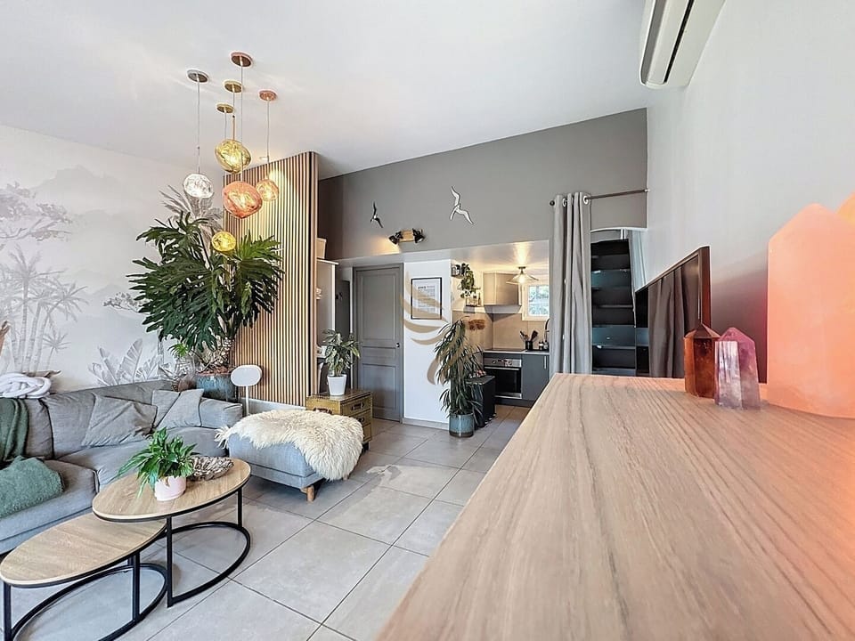 Profitez de ce salon cosy, aménagé avec un canapé d'angle confortable et une table basse élégante pour partager des moments chaleureux et détendus.