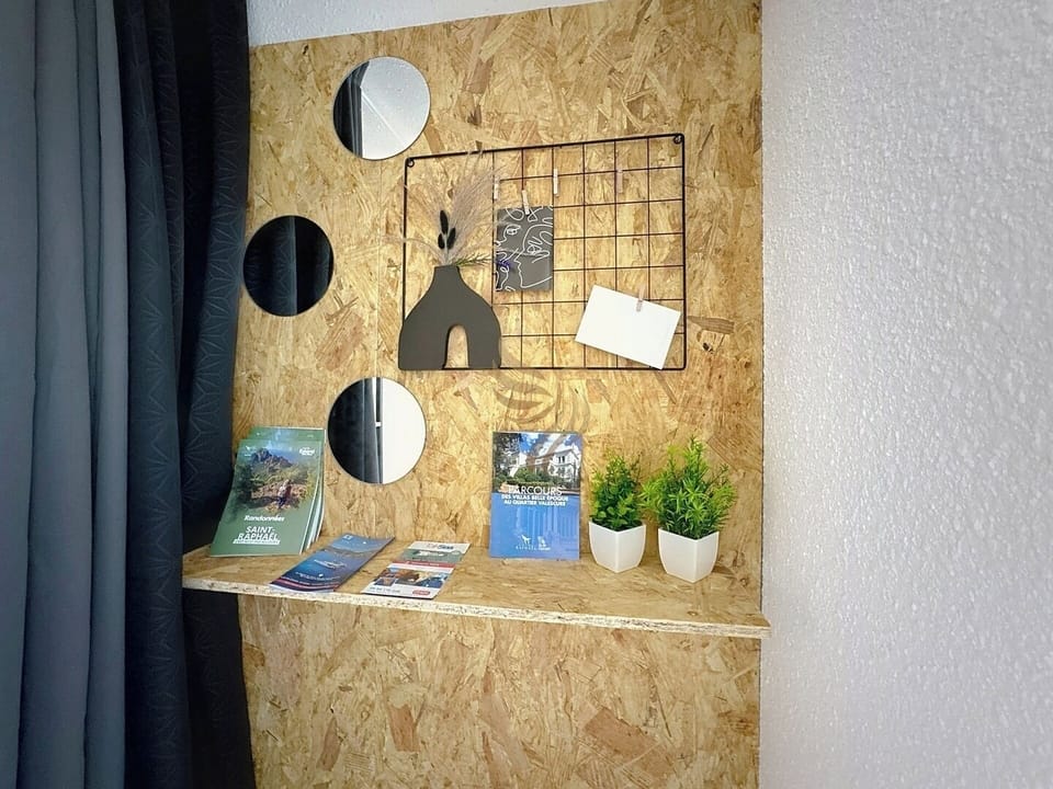 Pratique pour planifier votre séjour, ce coin offre des brochures locales. L'étagère minimaliste en bois aggloméré ajoute une touche moderne tout en maximisant l'espace.
