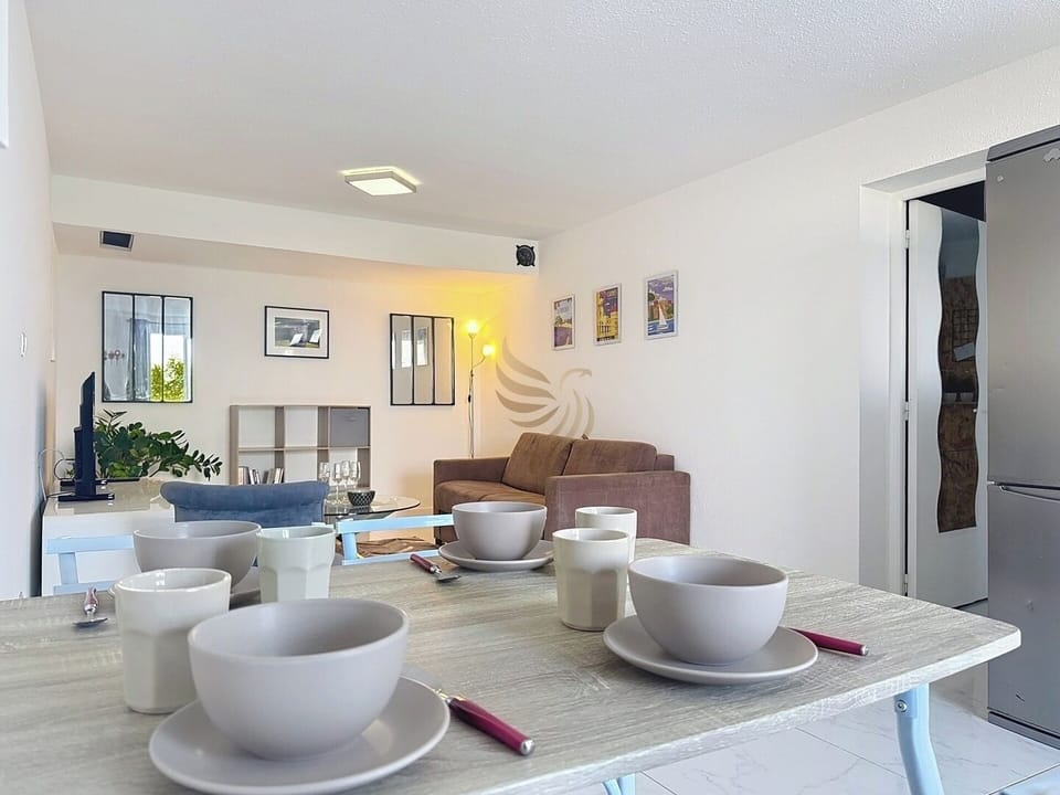 La table à manger peut devenir le centre de grandes soirées conviviales grâce à son agencement pratique et l'ouverture sur le salon permet des interactions fluides entre les invités.