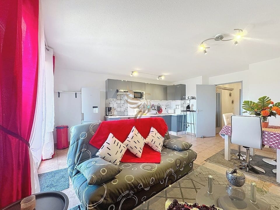 Profitez d'un espace convivial. Après un repas à la table élégamment décorée, détendez-vous sur le canapé moderne en appréciant l'ambiance lumineuse et ouverte.
