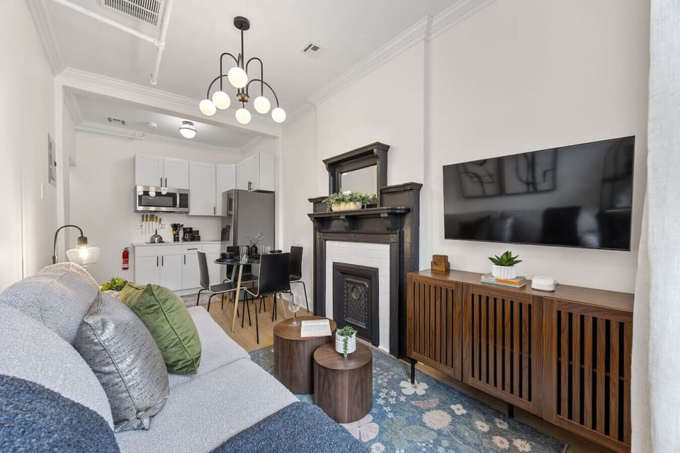 Welcome to our NYC apartment! Cozy up in our inviting living room, complete with comfortable seating and a charming fireplace. The open floor plan makes it feel even more spacious.