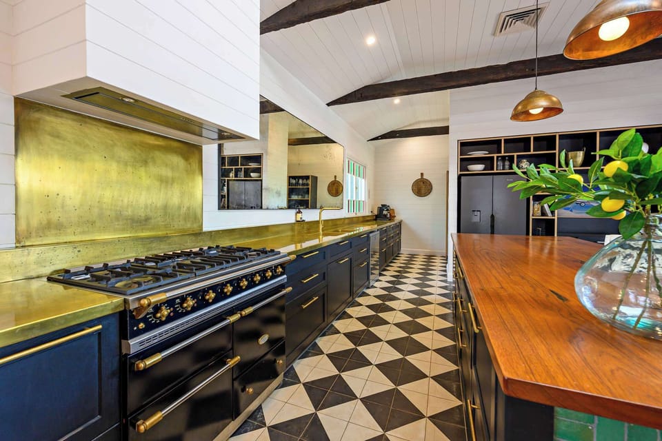 Designer kitchen with brass finishes, premium appliances and generous workspace — perfectly equipped for relaxed cooking and entertaining.