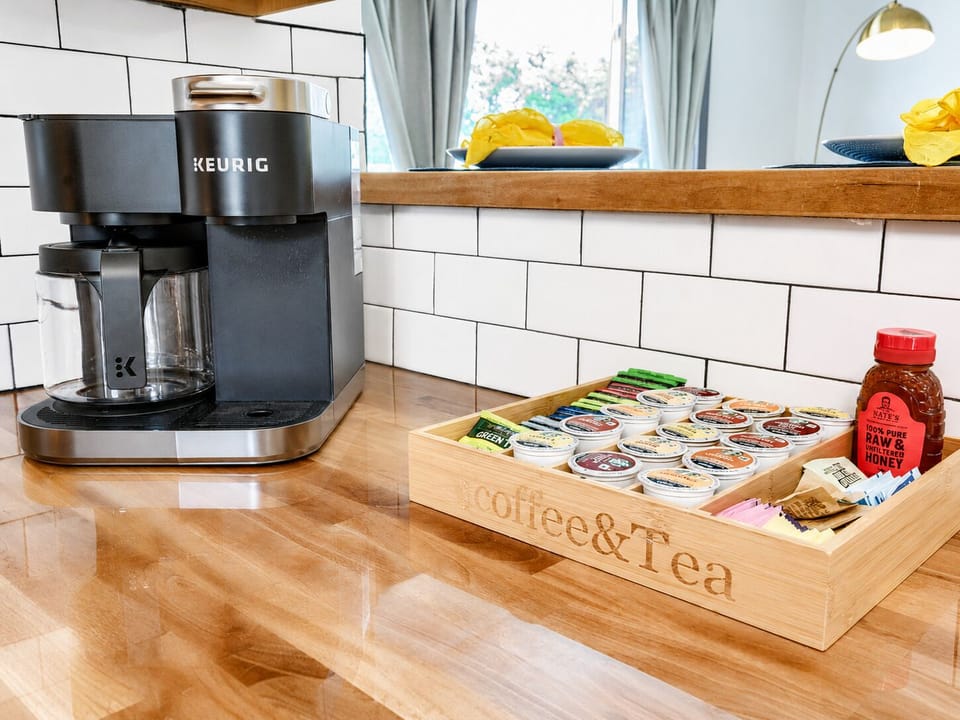 Bright coffee station with Keurig, tea selection, and thoughtful extras
