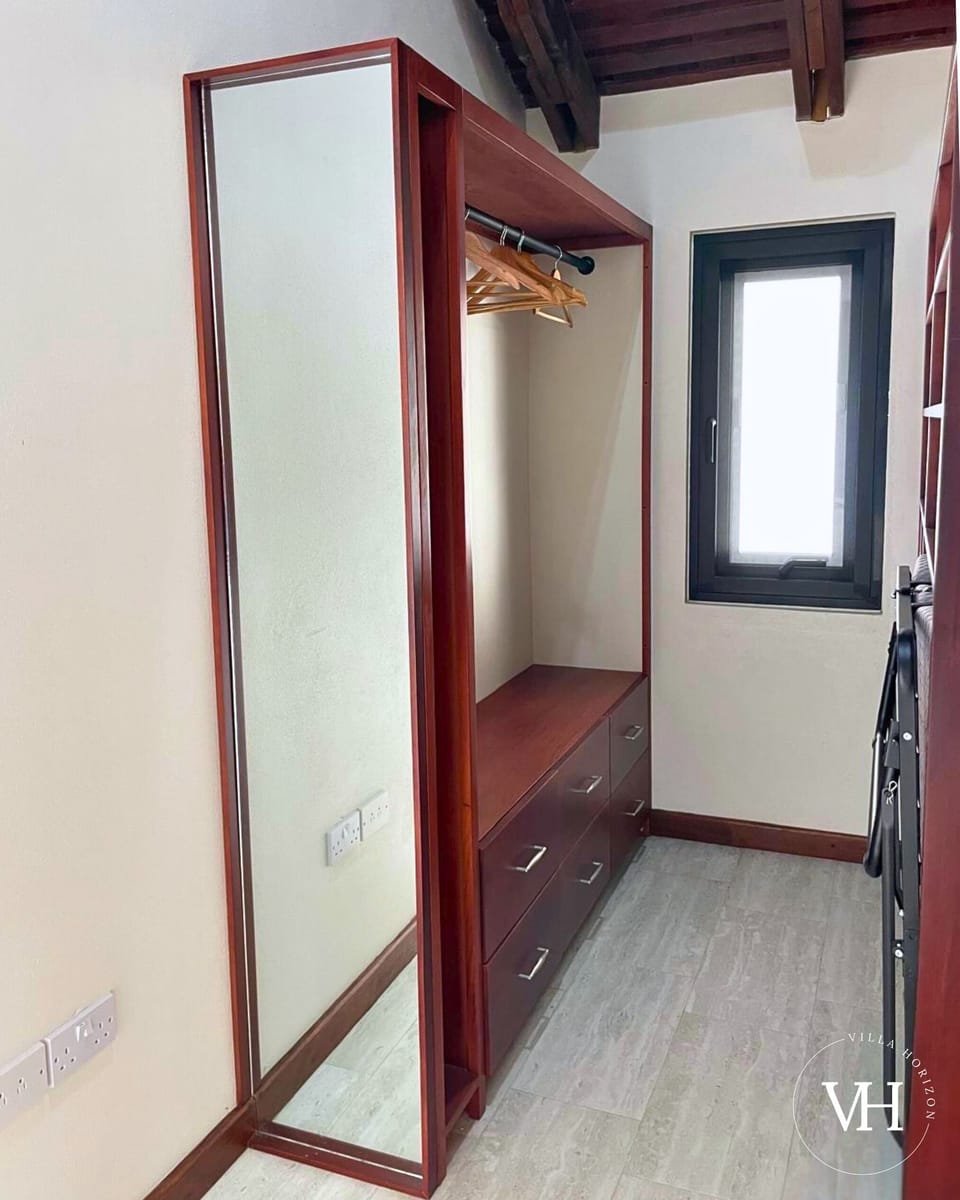 Gardenview Apt. - Wardrobe with extra pull-out bed, hangers, iron, and safe for secure storage.