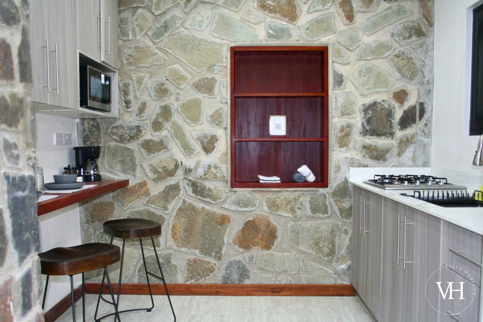 Soursop Suite - Full kitchen with fridge, stove, sink, cooking essentials, and coffee station.
