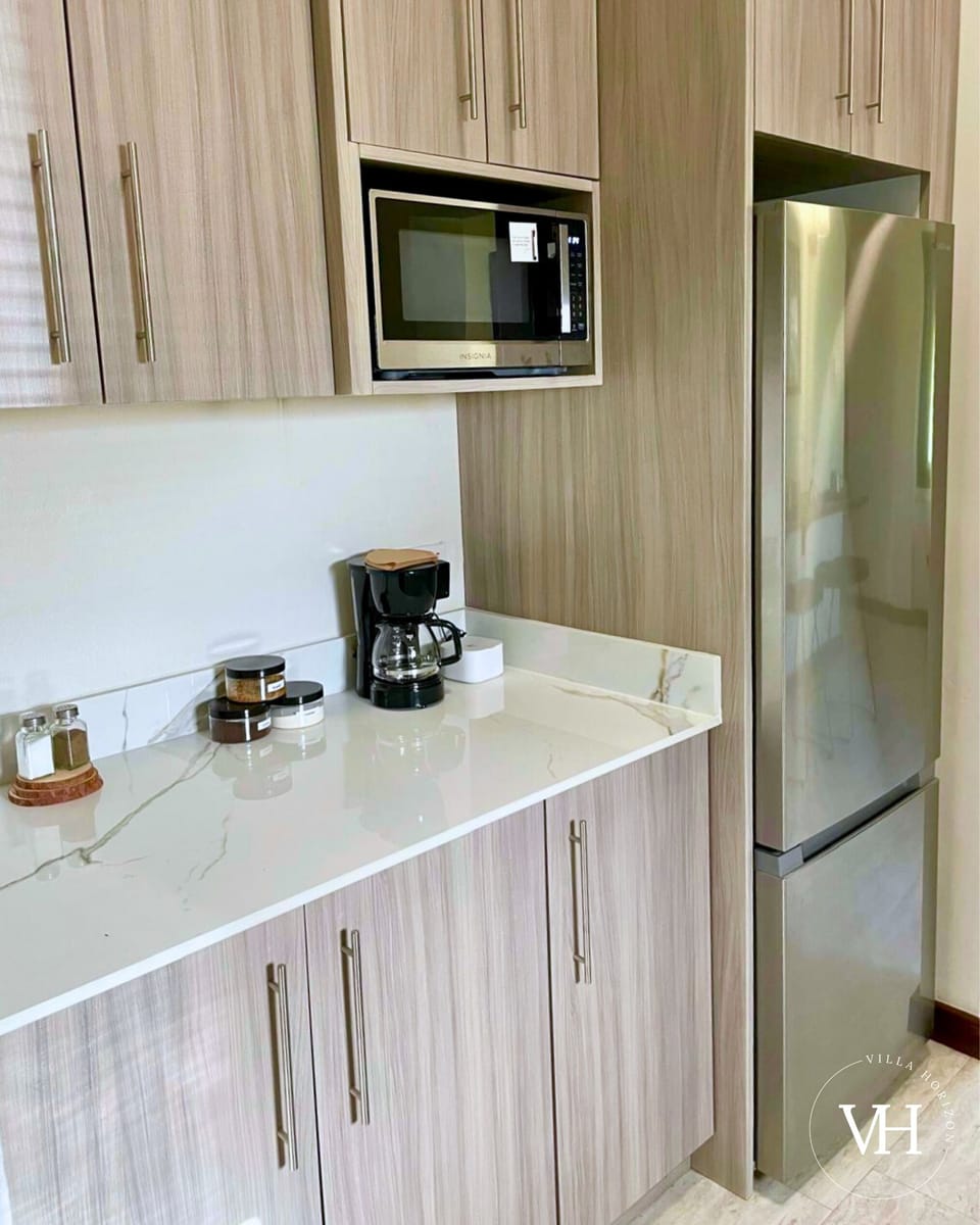 Full kitchen with fridge, stove, sink, cooking essentials, and a complimentary coffee station. (2)