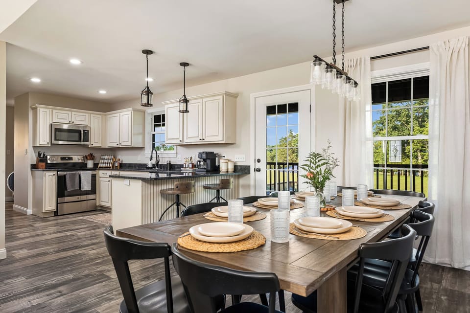 A beautifully appointed kitchen and dining area with seating for the whole group, modern pendant lighting and a view of the property right from the table. Gathering here feels effortless.