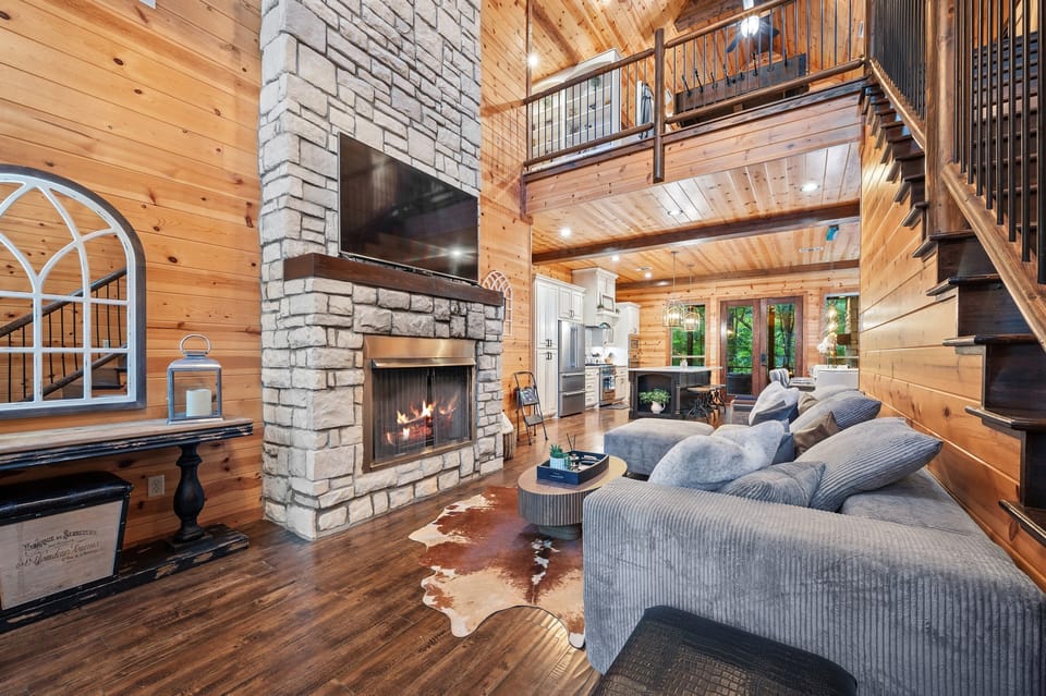 The living room has vaulted ceilings and surrounded by windows