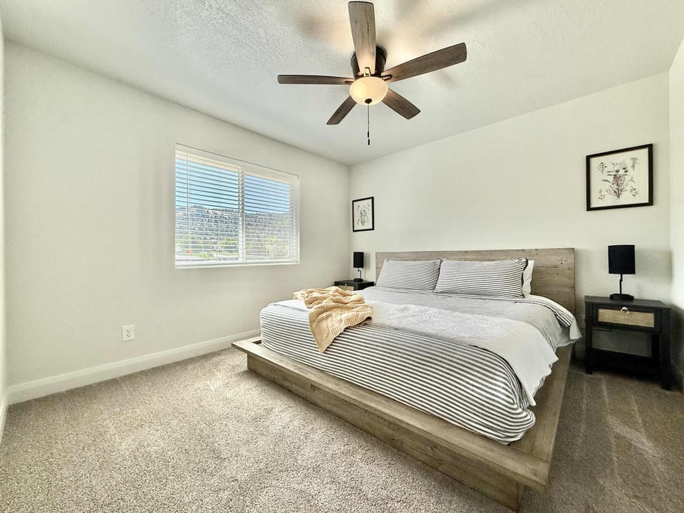 Bedroom 2 features a plush king sized bed, ceiling fan, night stands, and closet