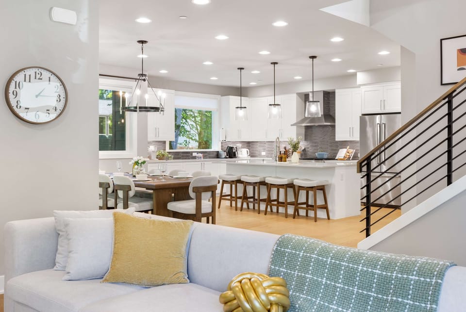 Open living-kitchen​ with cozy sofa, dining table, and kitchen island.