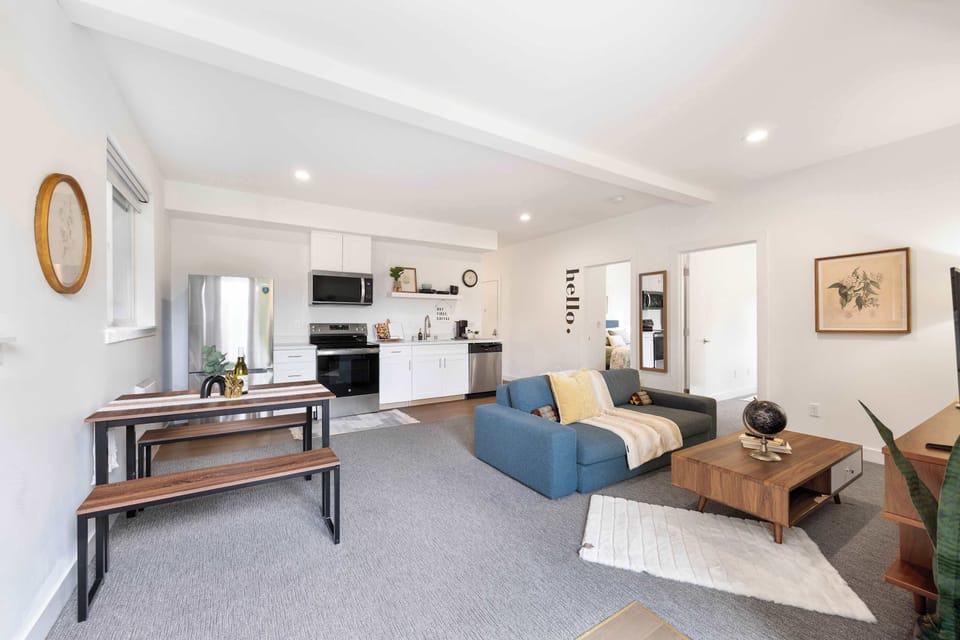 Open-plan living area with a blue sofa and sunny kitchen.