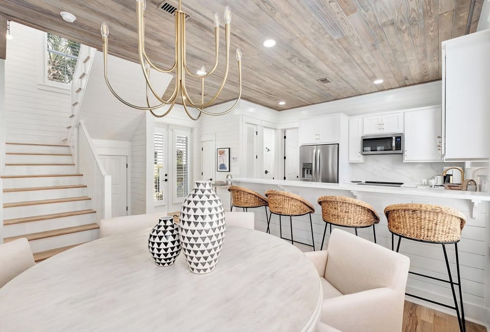 Stylish kitchen & dining view w/ warm wood ceilings and airy coastal details